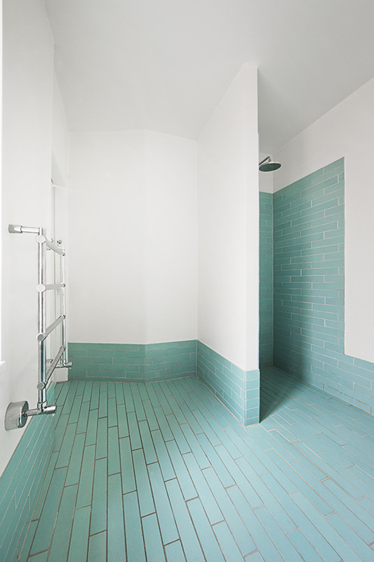 Grande salle de douche avec au sol, un carrelage vert clair et un carrelage blanc sur les murs