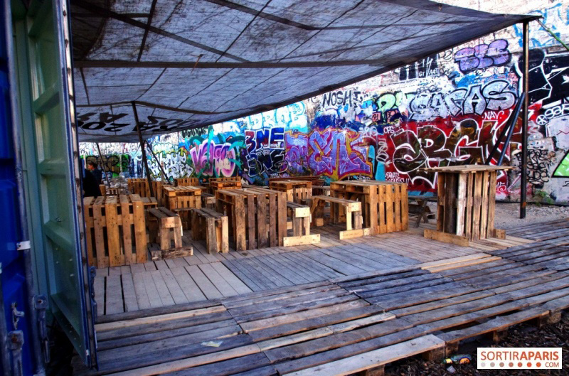 Le coin du bar, avec ses tables et ses bancs en palettes