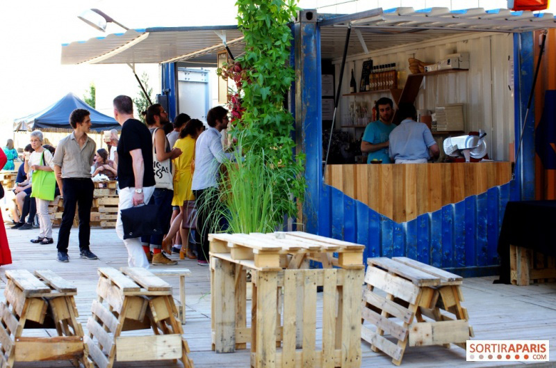 A côté du bar, tabourets faits de palettes sciées, et tables