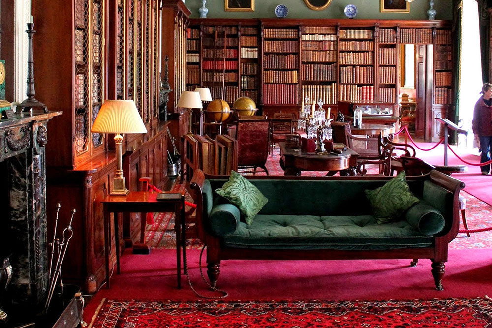 Une grande bibliothèque avec des tapis rouges et des meubles en acajou