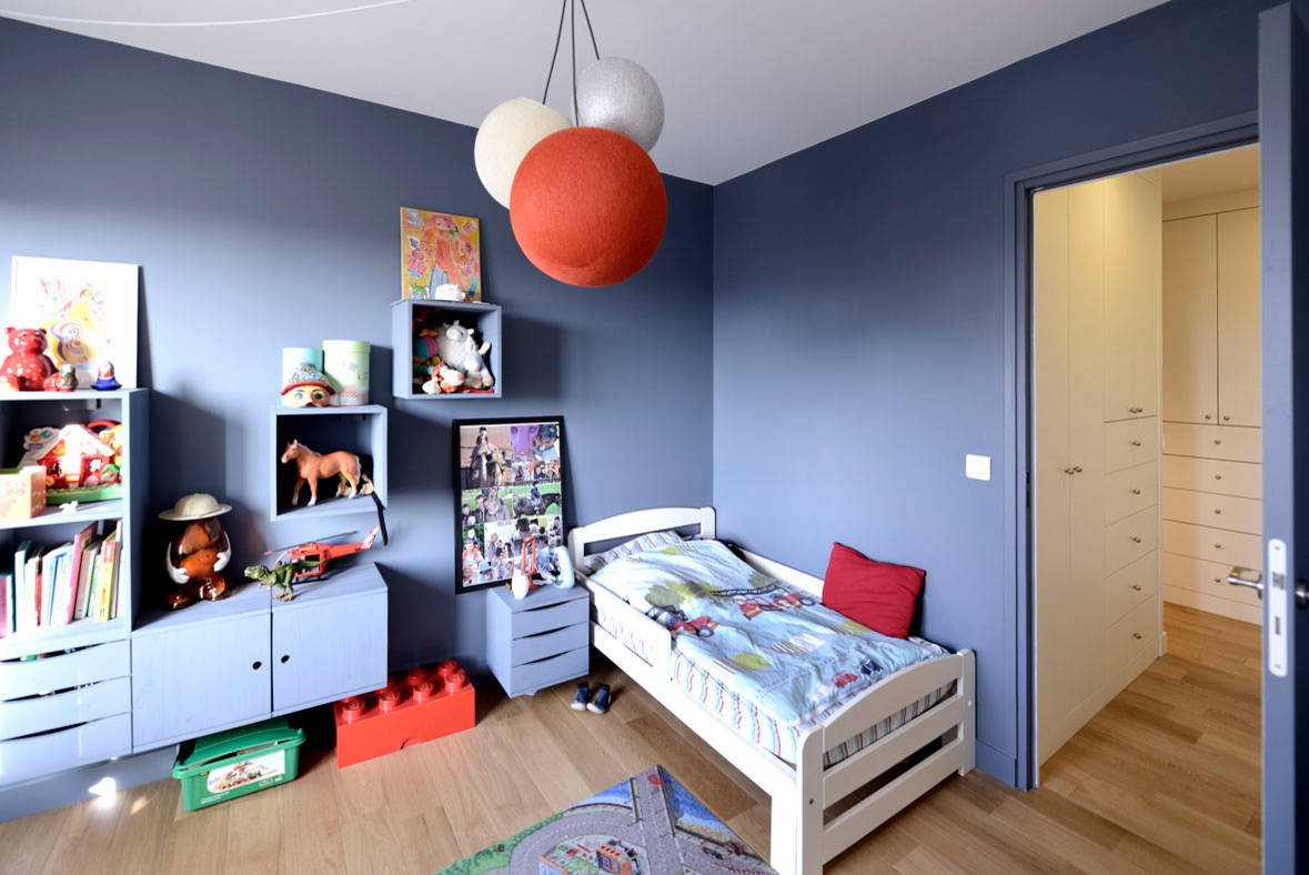 Chambre d'enfant bleue avec meubles en bois