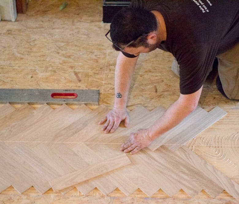 Parqueteur posant un parquet en motif à bâtons rompus