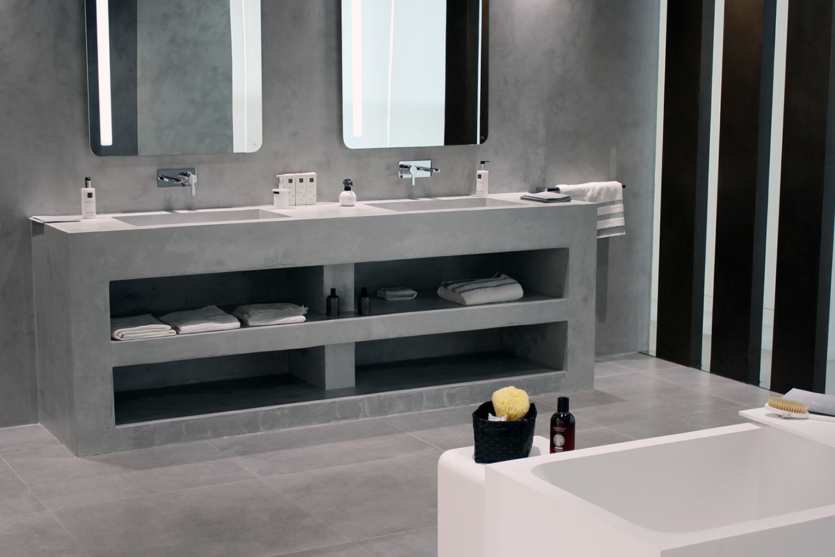 Un lavabo et des étagères recouverts en béton ciré gris clair