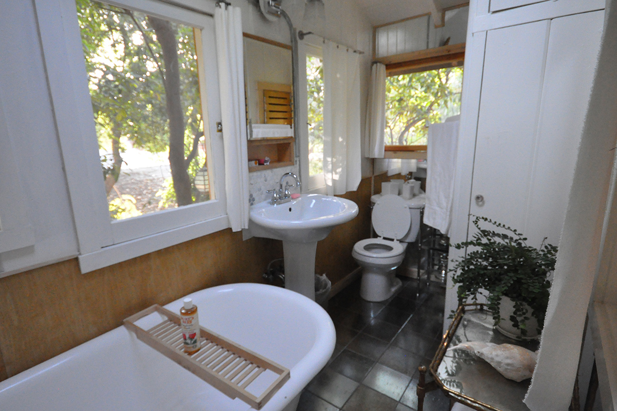 Trois fenêtres pour une petite salle de bains avec baignoire, lavabo et toilettes