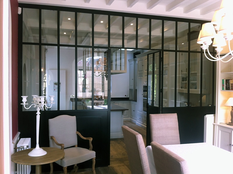 Une verri_re à grands carreaux verticaux et panneaux de fer forgé. 