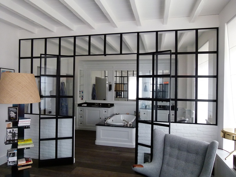 Une très grande salle de bains attenante à une grande chambre, dans les tons de noir et blanc